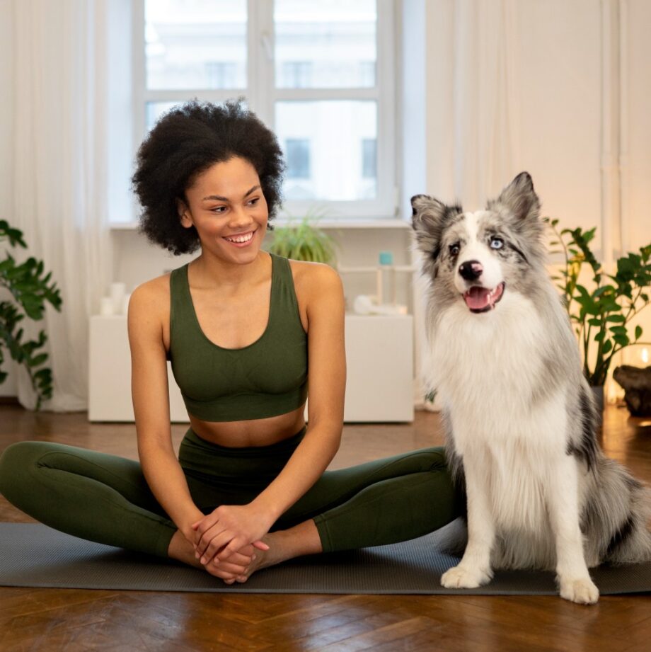 person doing yoga accompanied by her pet